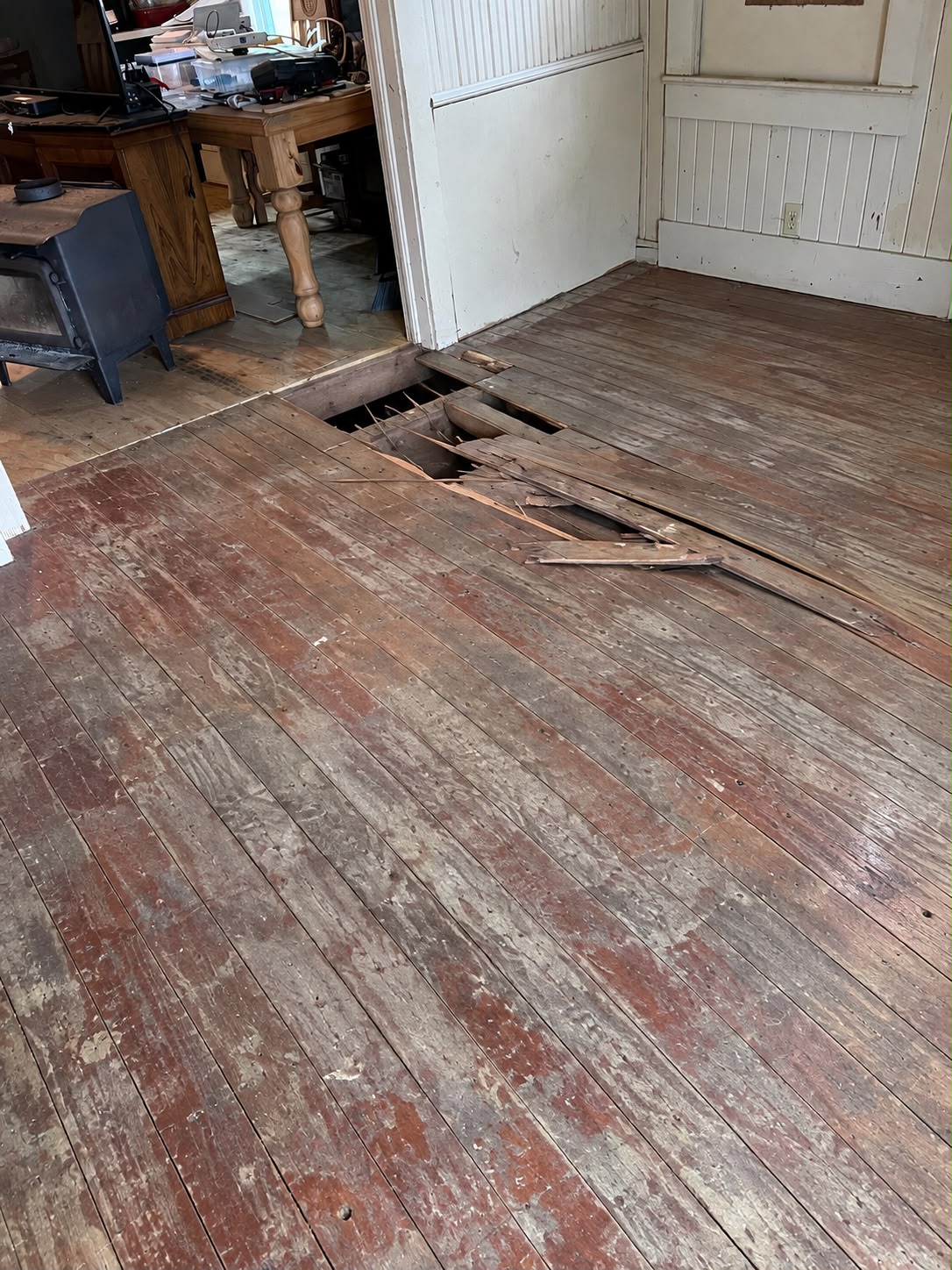 Damaged wood subfloor with a rotted opening before repair