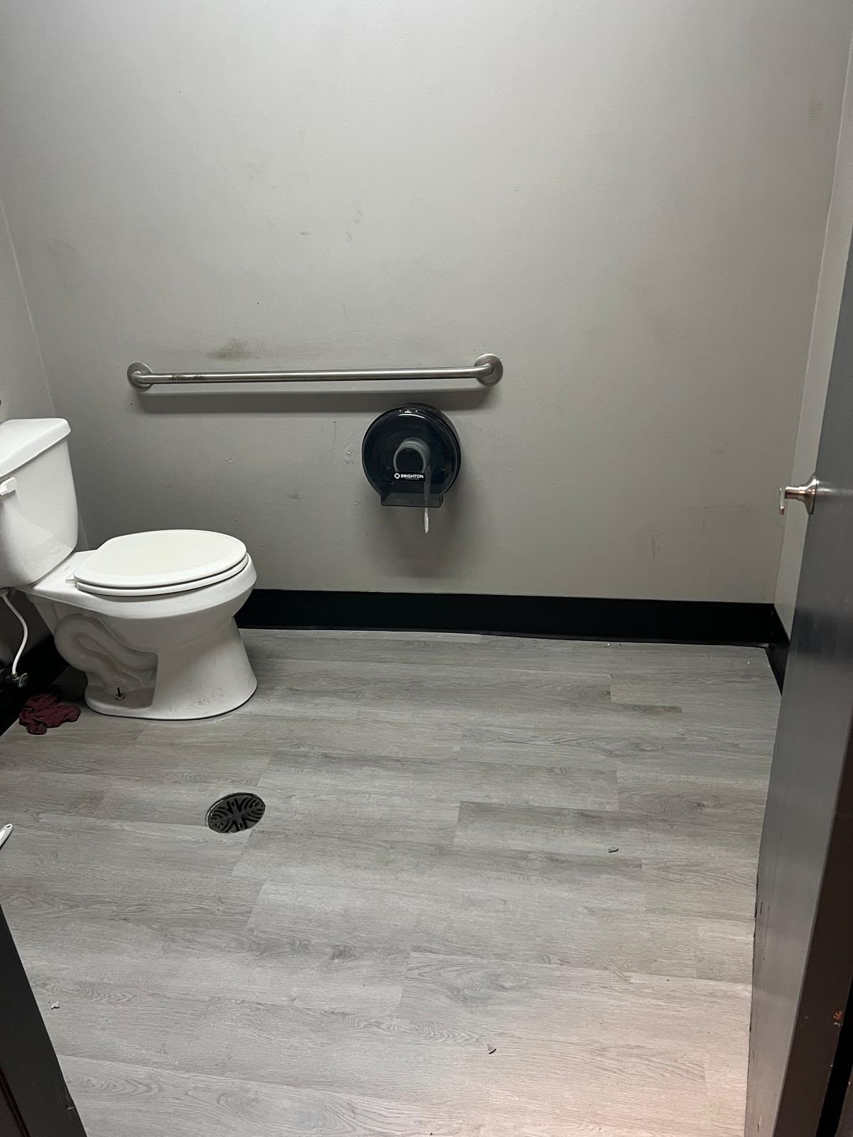 Restroom after update with gray vinyl plank flooring